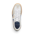 Direct overhead view of the shoe, displaying the Vapor Gray suede T-toe mudguard, white leather vamp, flat white laces, embossed white leather tongue, fold-over PUMA flap label, and navy cushioned footbed printed with repeating PUMA logos.