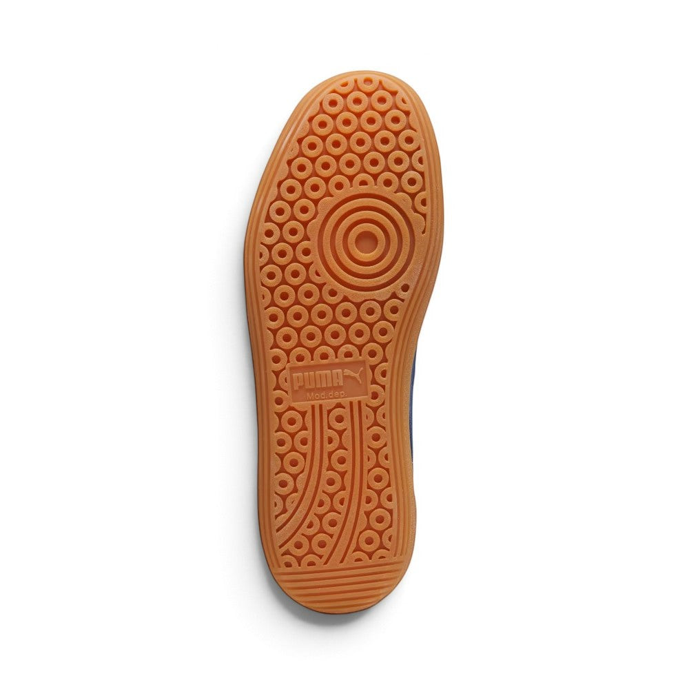 Full-length bottom profile showing the gum rubber outsole, highlighting the multi-pod suction cup tread pattern, circular forefoot pivot ring, perimeter grip blocks, and central recessed PUMA logo bridge.