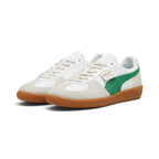Forward three-quarter angle showcasing both shoes side by side, highlighting the low-profile terrace silhouette, flat off-white laces, contrasting suede T-toe mudguards, green suede Formstrips, and clean gum rubber soles.