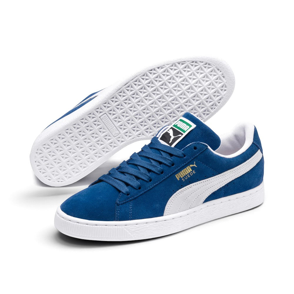 Three-quarter dynamic perspective displaying both shoes, highlighting the low-slung archival stance, tonal blue flat laces, textured white foxing, and the sharp contrast between the white outsole and blue suede chassis.