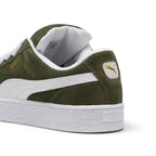 Close-up rear angle focusing on the reinforced suede heel counter, thick puffy Achilles collar padding, white leather heel moustache tab stamped with a gilded metallic PUMA Cat logo, and chunky textured cupsole base.