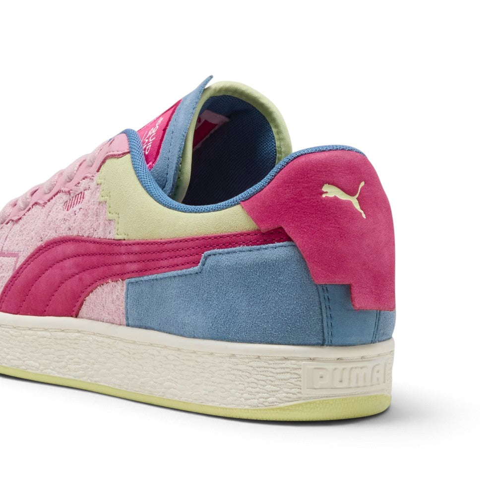 Close-up rear angle focusing on the geometric magenta suede heel moustache tab stamped with a gold-tone PUMA Cat logo, Blue Horizon suede lower heel wrap, soft blue mesh collar lining, and textured rubber sole border.