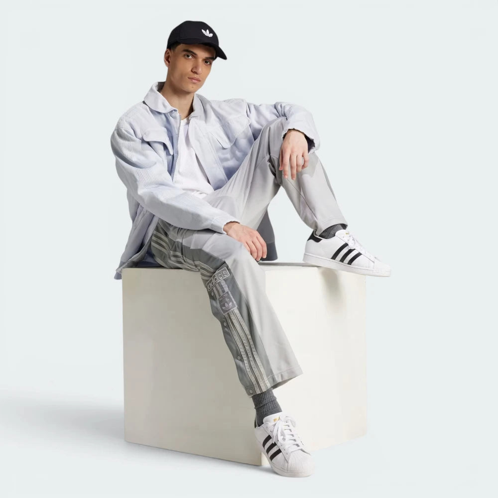 Highlights the high-velocity sweep of the continuous grey 3-Stripes and snap panels running flawlessly down the professional, matte depth of the Grey Two leg columns.