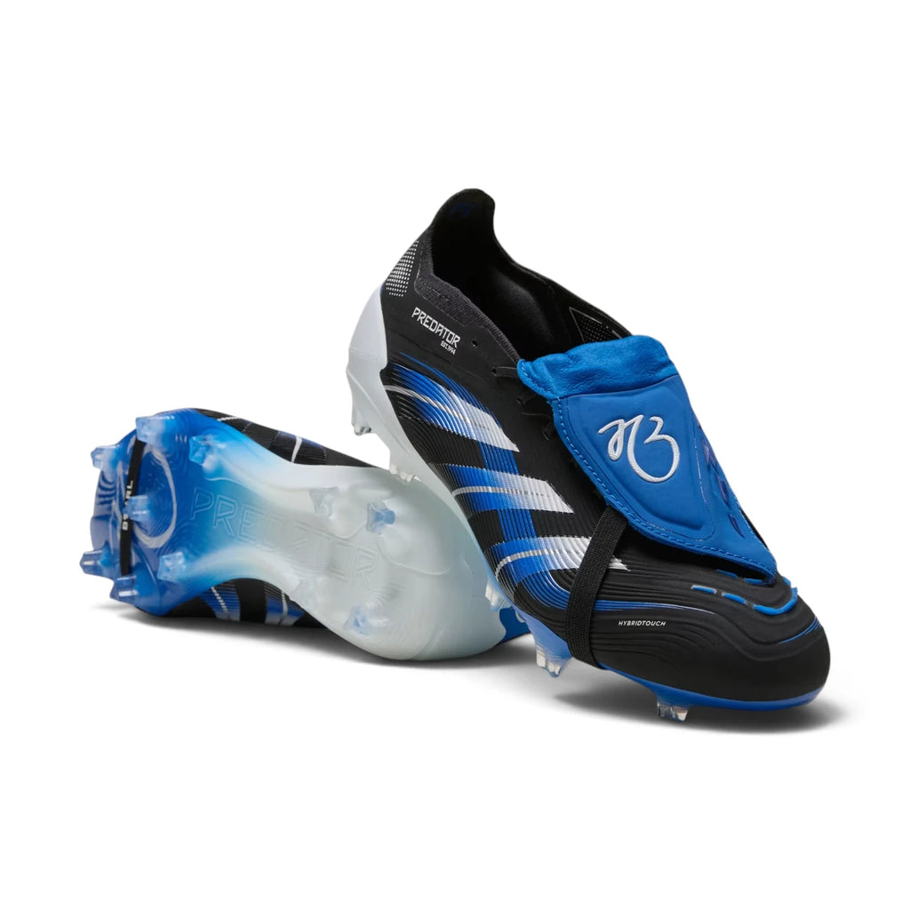 Studio layout of the adidas Predator Elite Jude Bellingham firm ground boots in Core Black and Glow Blue, showcasing one boot upright with the blue fold-over tongue and the second boot positioned to reveal the gradient blue Controlframe 2.0 outsole.