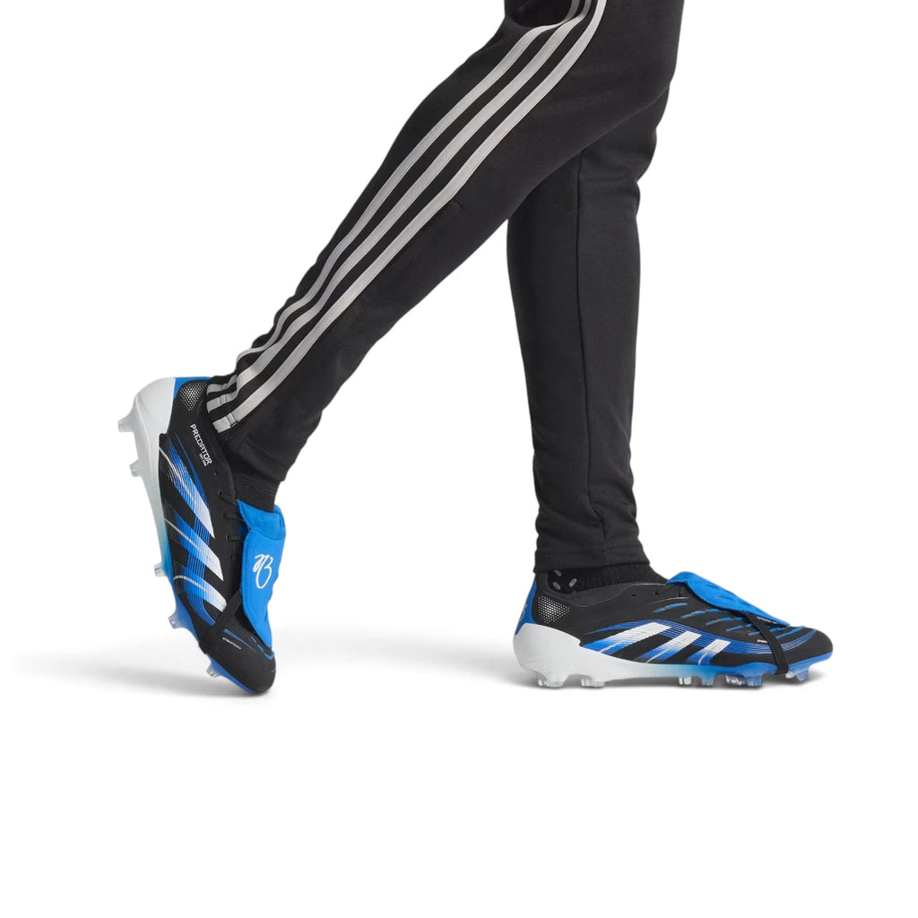 Action shot of a player wearing the black and blue Predator Elite boots, highlighting the sleek fit, side 3-Stripes branding, and the textured forefoot strike zone during movement.