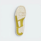 Displays the classic concentric-circle basketball traction pattern of the solid cream rubber sole, engineered for unreal everyday multi-surface street grip.