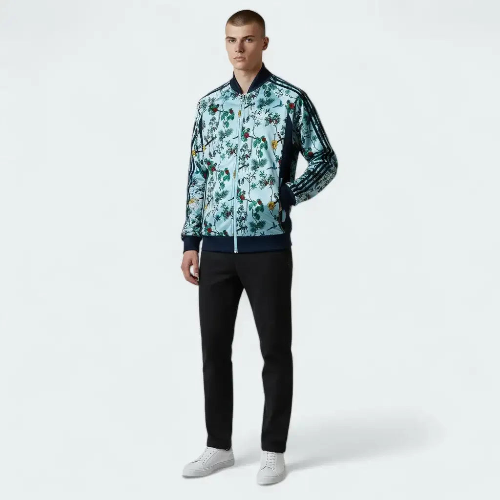 Man wearing a patterned jacket and black pants on a white background