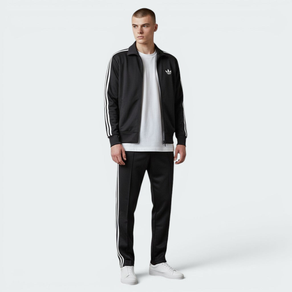 Focuses on the symmetry of the flat-laid track jacket, displaying the perfect alignment of the high stand-up funnel collar, the central zip track, and the balance of the embroidered Trefoil logo on the chest.