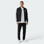 Focuses on the symmetry of the flat-laid track jacket, displaying the perfect alignment of the high stand-up funnel collar, the central zip track, and the balance of the embroidered Trefoil logo on the chest.