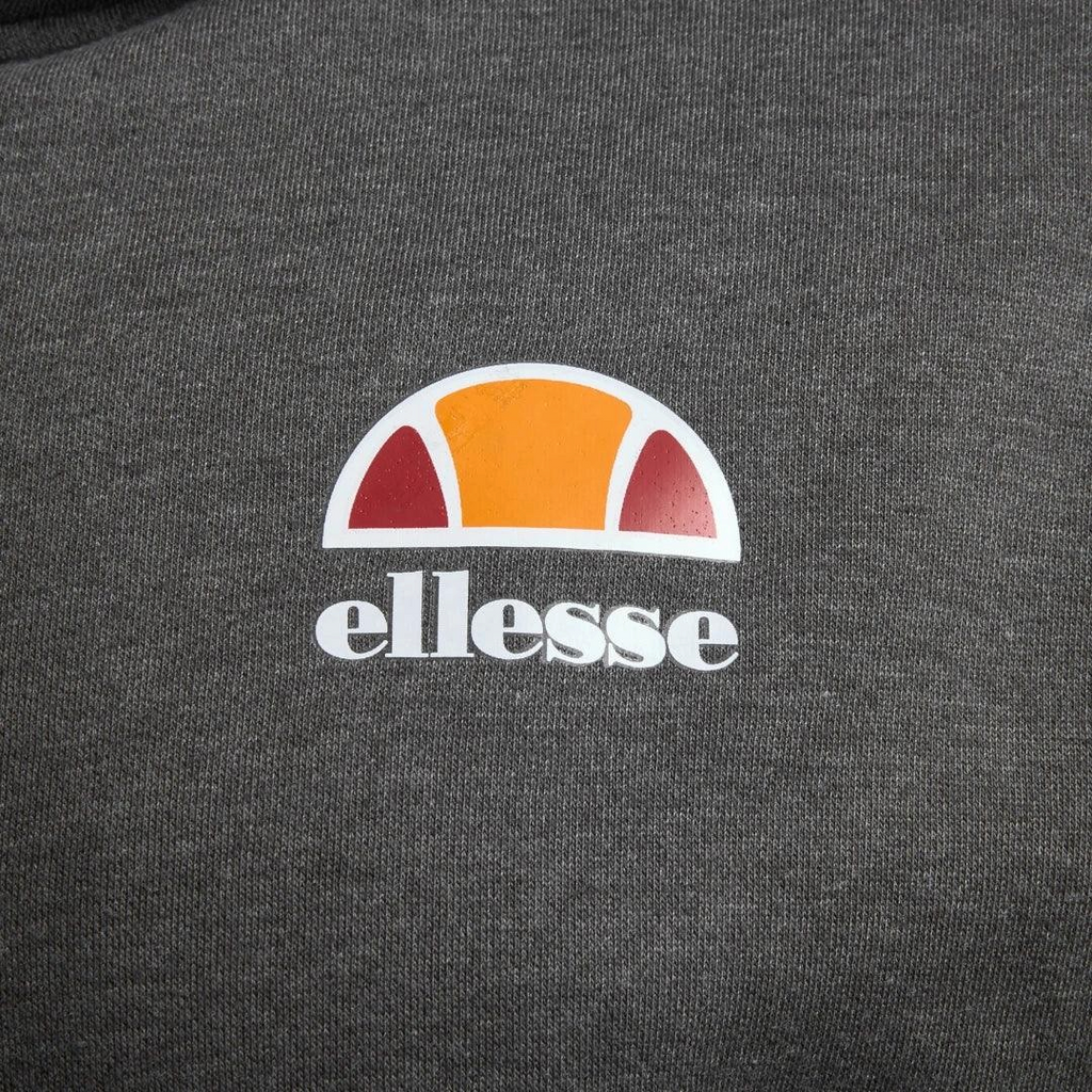Close-up zoom on the fabric of the Ellesse Toce Overhead Hoodie in charcoal, showing the soft fleece texture and the embroidered or printed Ellesse logo.