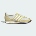 The Ivory SL 72 OG, highlighting the slim profile and the vibrant Power Yellow Three-Stripes against the neutral nylon.