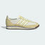 The Ivory SL 72 OG, highlighting the slim profile and the vibrant Power Yellow Three-Stripes against the neutral nylon.