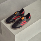 Looking down at the black lacing system and the official Manchester United badge on the tongue.