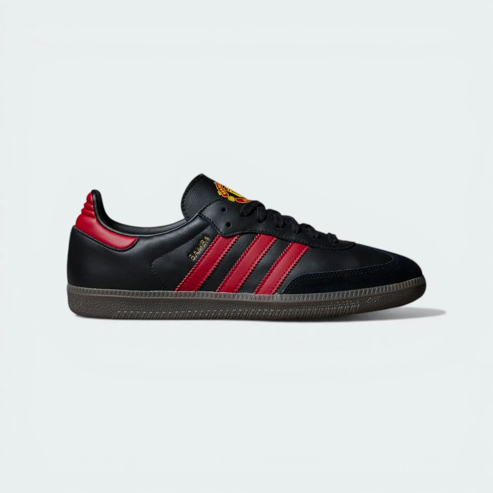 The Manchester United Samba, highlighting the Real Red 3-Stripes and the iconic translucent gum sole.