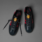 Looking down at the black lacing system and the official Manchester United badge on the tongue.