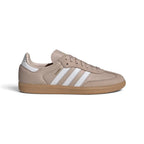 Displays the full lateral silhouette featuring the smooth Wonder Taupe leather upper, contrasting Cloud White serrated 3-Stripes, gleaming metallic gold foil "Samba" lettering, matching white heel tab, and the classic gum rubber cupsole.