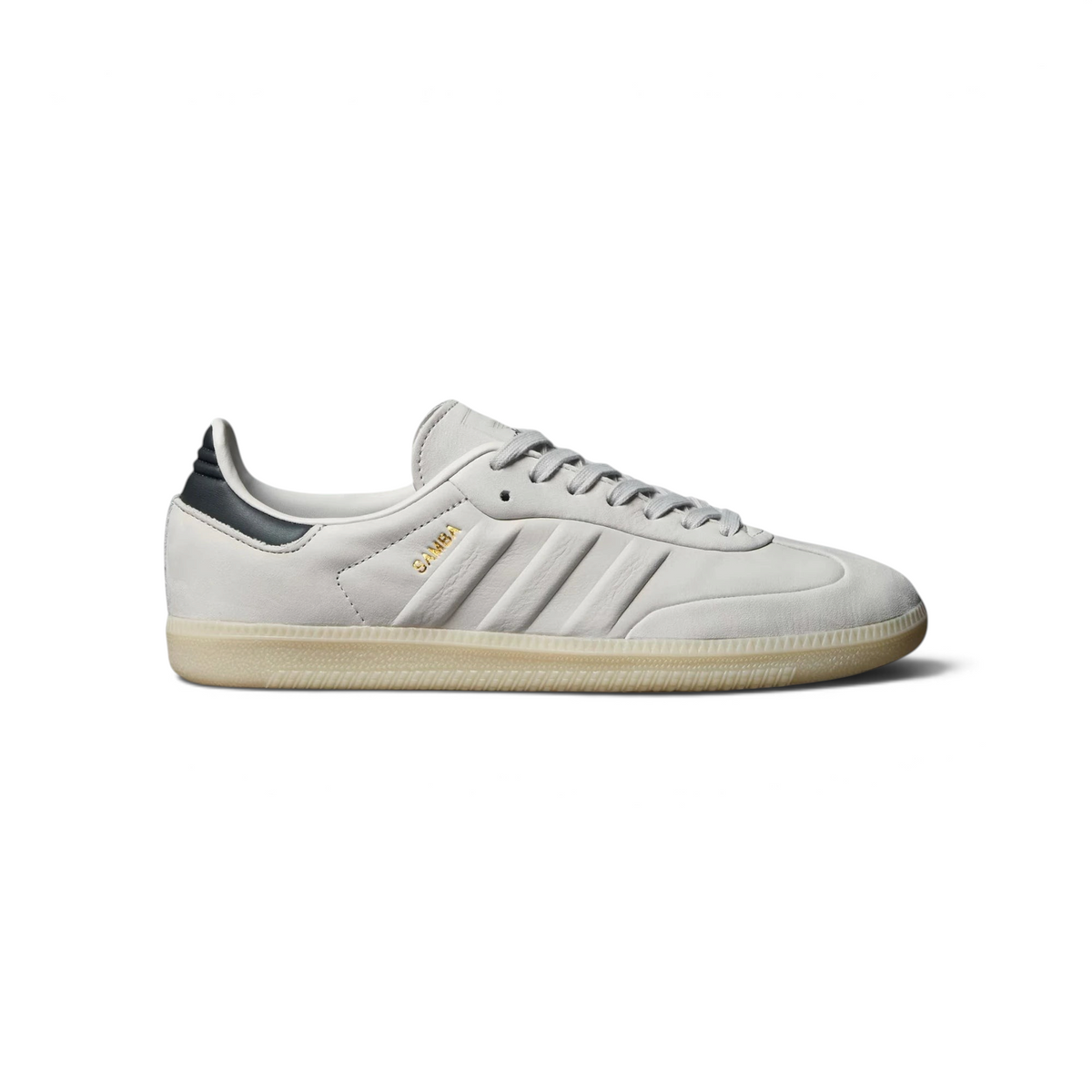 Highlights the high-velocity sweep of the Carbon grey serrated 3-Stripes, the professional gold-foil Samba text, and the striking visual depth of the Grey One butter soft leather upper. Main image