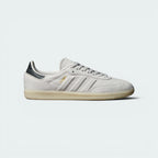 Highlights the high-velocity sweep of the Carbon grey serrated 3-Stripes, the professional gold-foil Samba text, and the striking visual depth of the Grey One butter soft leather upper.