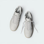 Focuses on the locked-in lace closure layout, the clean alignment of the premium leather eyestays, and the minimalist texture covering the soft leather tongue.