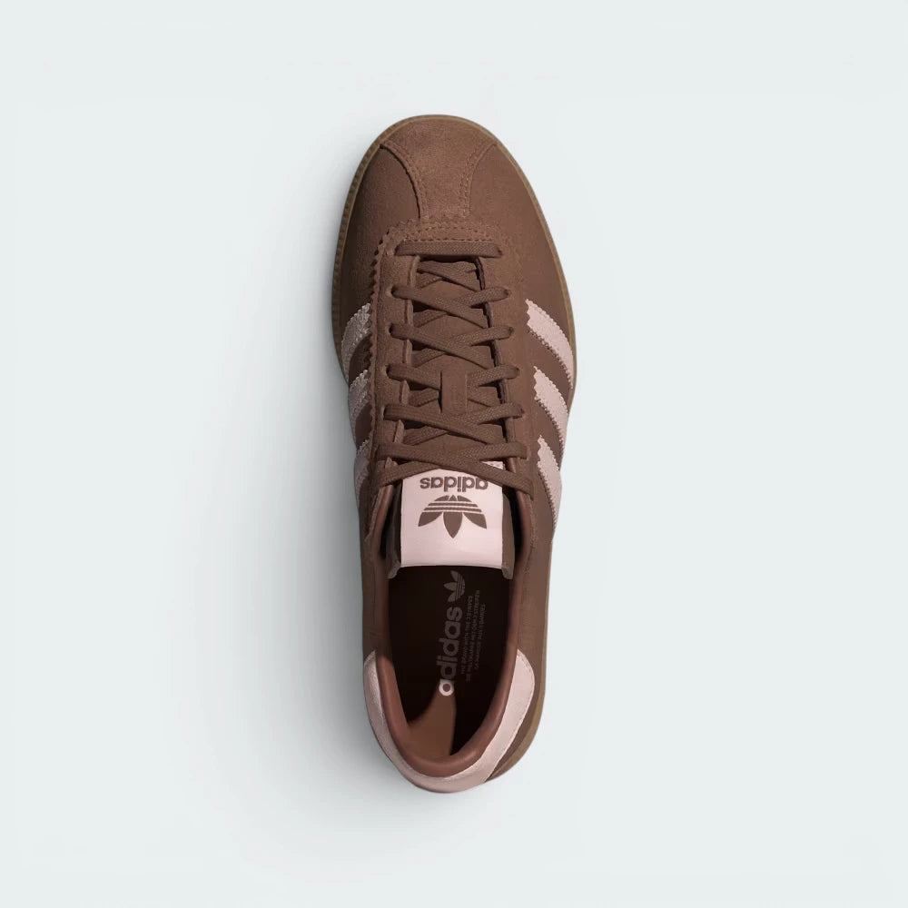 Focuses on the locked-in lace closure layout, the clean alignment of the soft brown suede tongue, and the iconic stitch line curving across the front box.