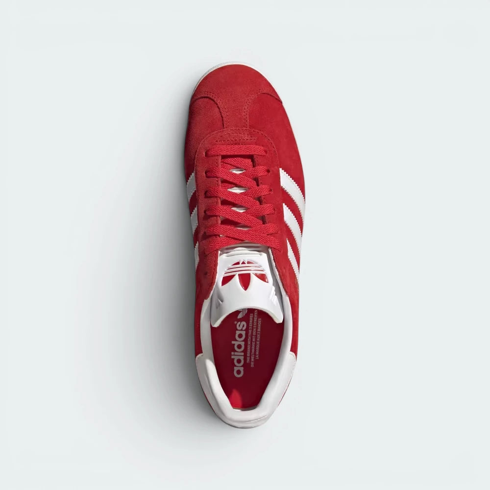 Focuses on the tidy lace closure, the clean alignment of the textured white tongue, and the symmetry of the smooth red suede toe caps.