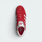 Focuses on the tidy lace closure, the clean alignment of the textured white tongue, and the symmetry of the smooth red suede toe caps.