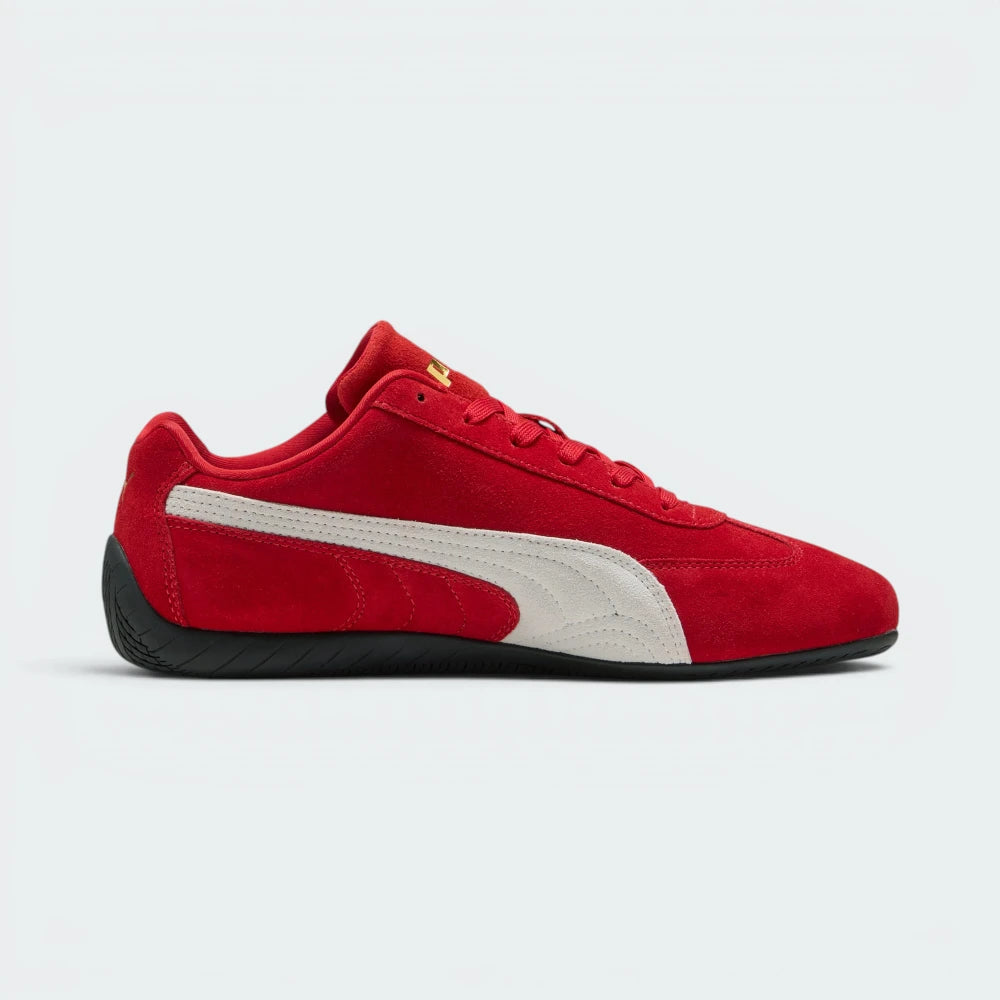 Details the premium precision of the white embroidered Puma Cat logo sitting on the red suede toe box, highlighting the soft nap of the suede, the clean eyelet stitching, and the gold foil Puma branding on the side.