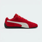 Details the premium precision of the white embroidered Puma Cat logo sitting on the red suede toe box, highlighting the soft nap of the suede, the clean eyelet stitching, and the gold foil Puma branding on the side.