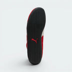 Displays the complete tire-tread tread pattern of the durable black rubber sole, featuring a contrasting red Puma Cat logo engineered for multi-directional grip.