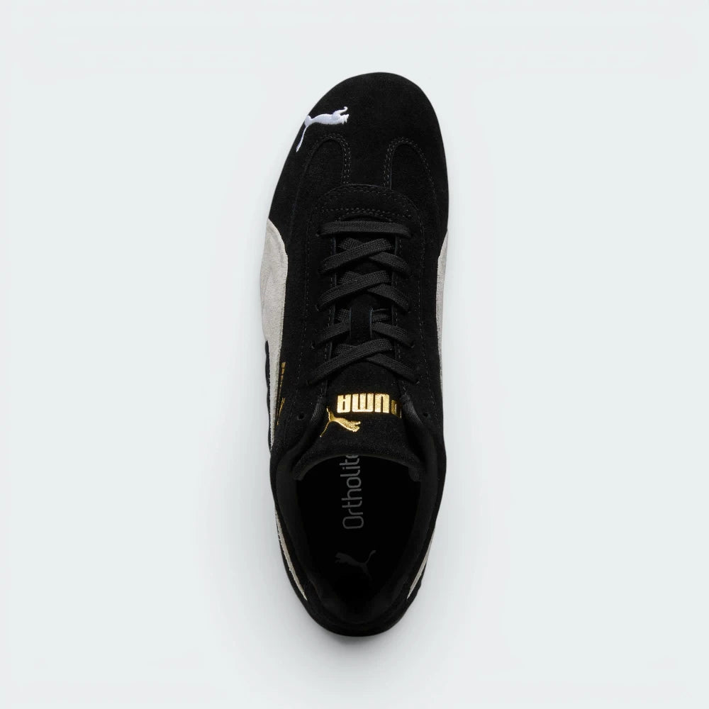 Focuses on the locked-in traditional lacing layout, displaying the clean symmetry of the black suede tongue, the gold foil Puma logo, and the breathable black OrthoLite® footbed inside.