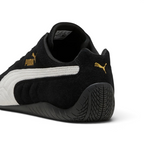 Focuses on the rounded driver's heel design, showcasing the tire-tread textured black rubber wrapping up the rear spine, finished with a small metallic gold Puma Cat logo.