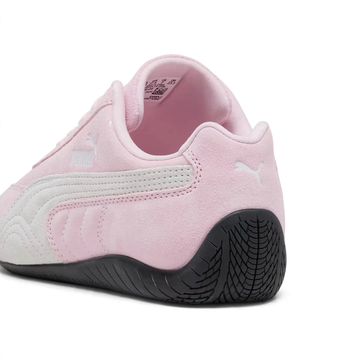 Close-up rear angle focusing on the iconic curved rubber driving heel, vertical heel seam, and crisp embroidered white PUMA Cat logo above the wrapped tread.