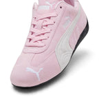 Macro focus on the front forefoot, detailing the fine pink suede texture, stitched central seam, and the embroidered white PUMA leaping cat on the toe.