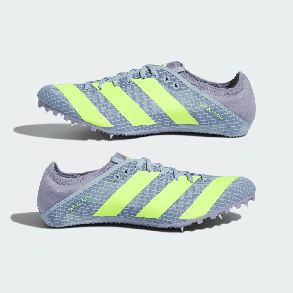 Pair of gray running shoes with green stripes on a light gray background