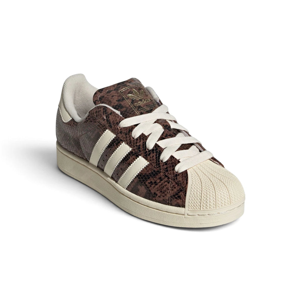 Angled front-three-quarter perspective capturing the iconic rubber shell toe, snakeskin texture, and contrasting Alumina white side stripes