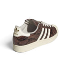 Rear-facing perspective focusing on the cream white leather heel tab with gold foil Trefoil branding, stitched rear collar seams, and the clean sidewall wrap of the sole.
