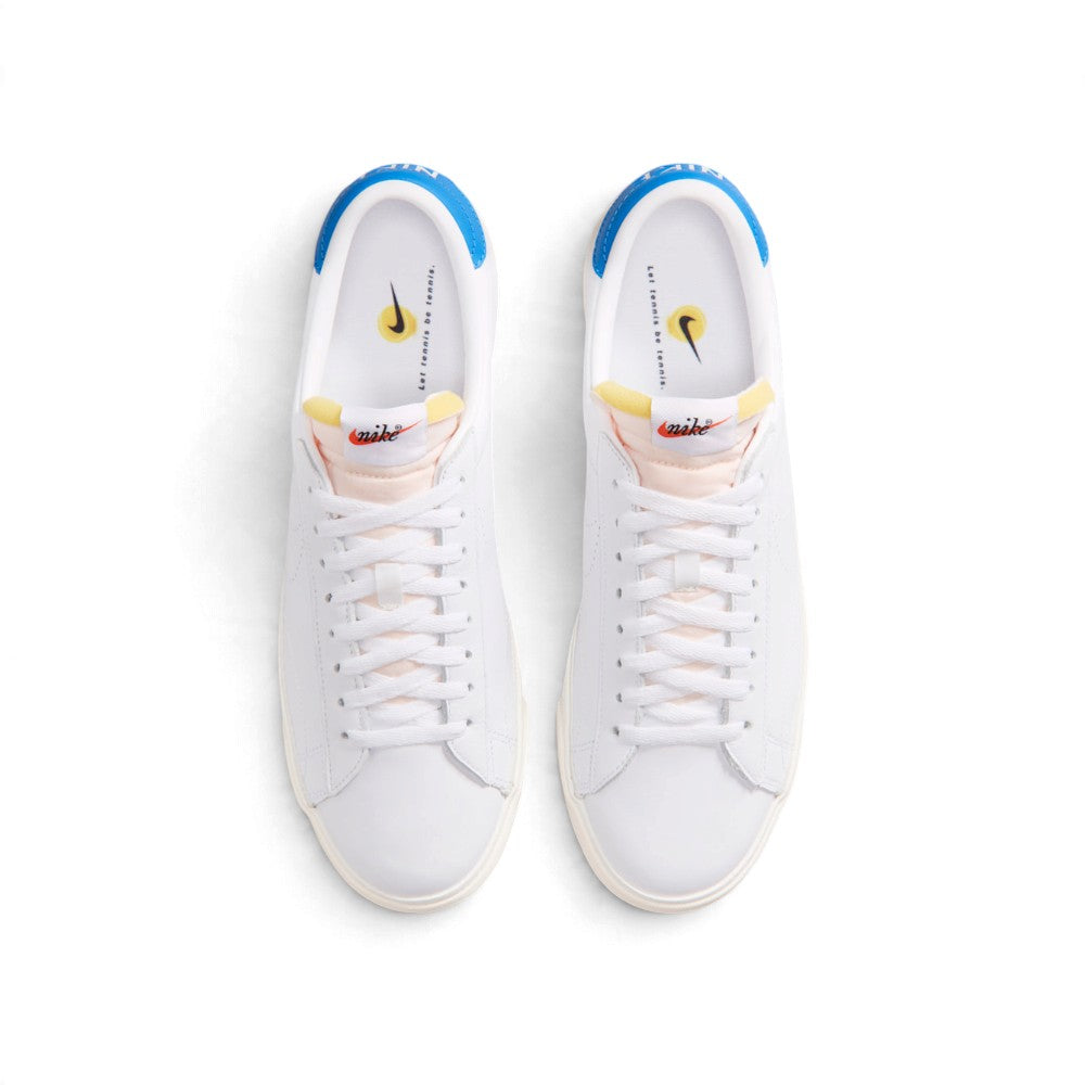 Overhead view of both sneakers showing the central lacing system, peach-tinted tongues, and insoles printed with "Let tennis be tennis.