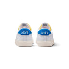 Rear view of the sneakers emphasizing the blue leather heel tabs featuring crisp white "NIKE" lettering.