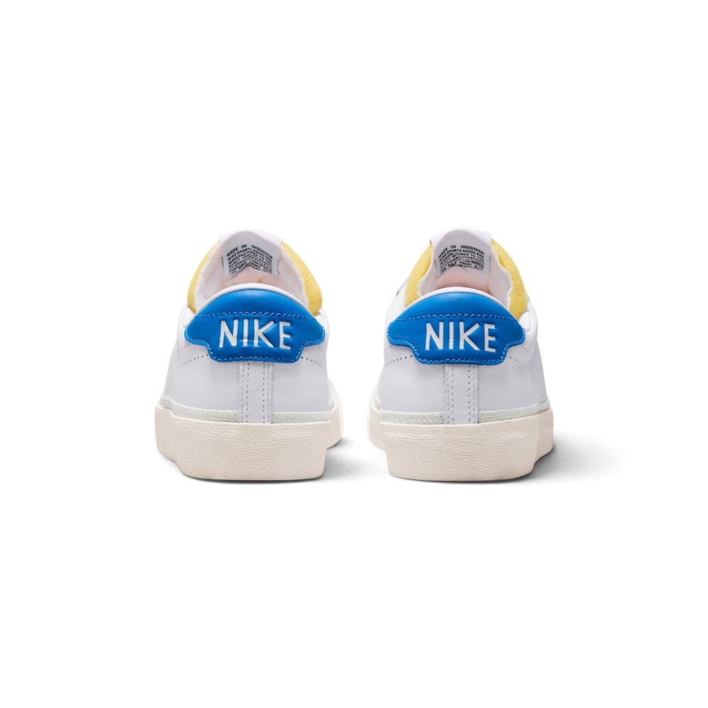 Rear view of the sneakers emphasizing the blue leather heel tabs featuring crisp white "NIKE" lettering.