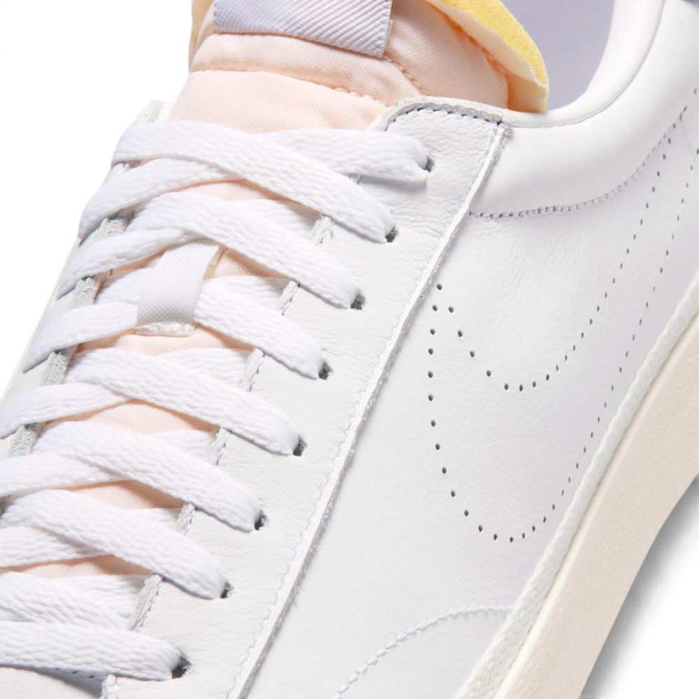 Macro focus on the forefoot and eyestay, detailing the fine leather grain, flat white laces, and perforated side Swoosh lines.   