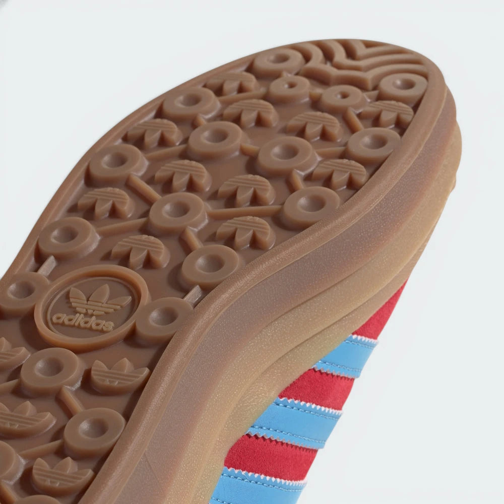 Close-up of an Adidas shoe sole with brand logo and striped sock.