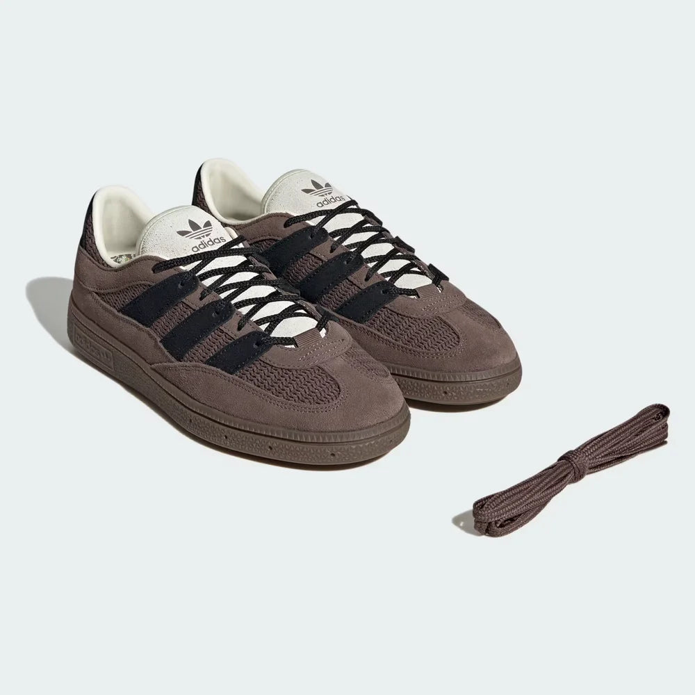 Brown Adidas sneakers with black stripes and laces on a light gray background