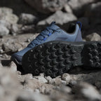 Blue hiking shoes with black soles on a rocky surface
