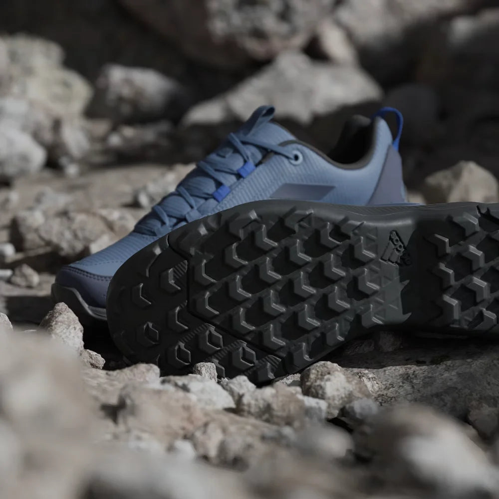 Blue hiking shoes with black soles on a rocky surface