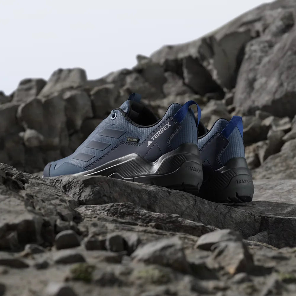 Blue and black shoes on a rocky surface