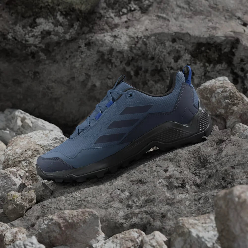 Blue athletic shoe on a rocky surface