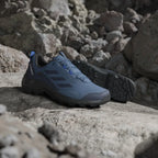 Blue hiking shoes on a rocky surface