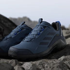 Blue hiking shoes with black accents on a rocky surface