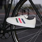 White sneaker with colourful stripes on a bicycle wheel