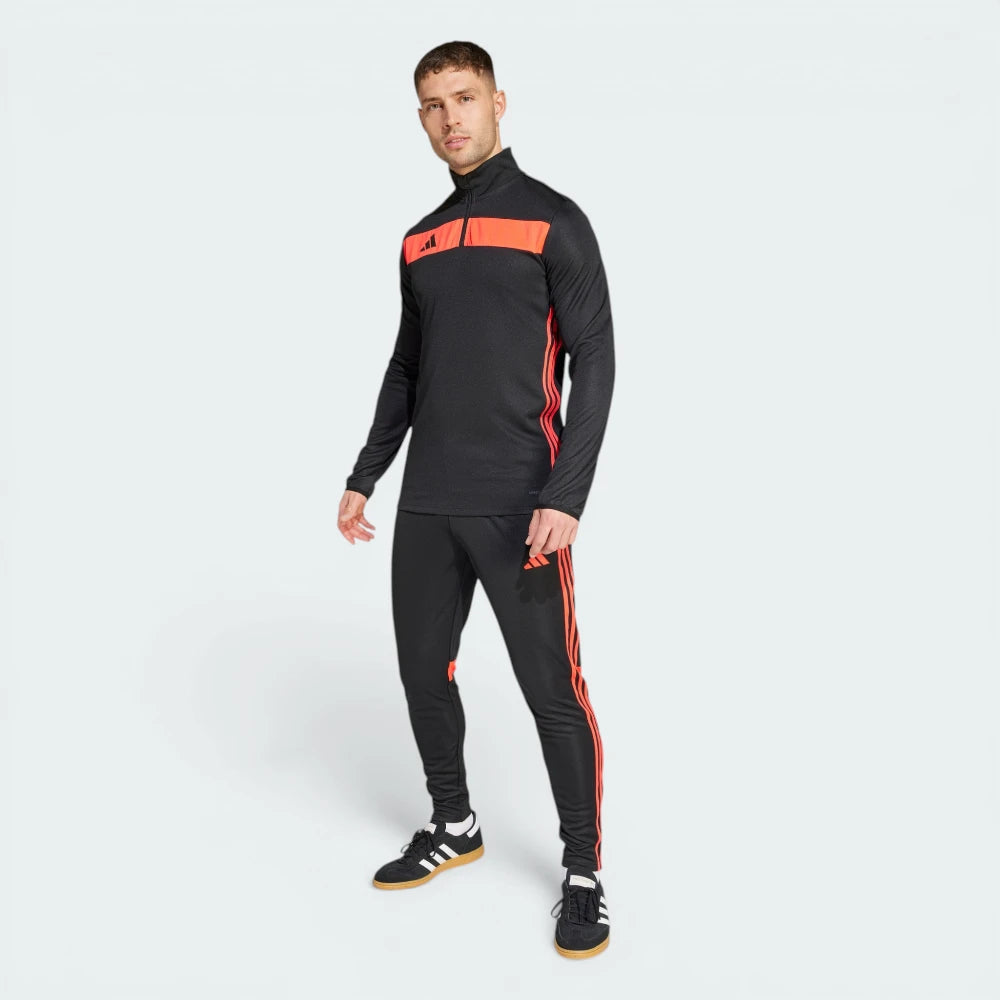 Man wearing a black and red tracksuit with Adidas logo on a white background
